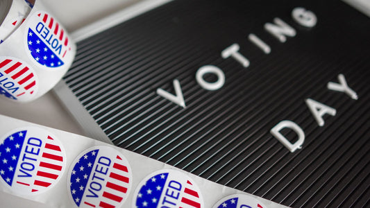 Roll of I Voted stickers beside a Voting Day sign