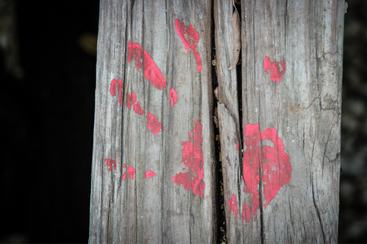 Wood with a red-painted hand print.