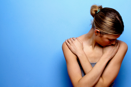 A woman crossing her arms across her chest in embarrassment.